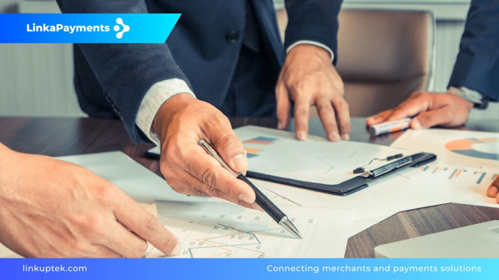 Imagen corporativa de LinkAPayments que muestra a profesionales analizando gráficos y documentos financieros sobre una mesa de madera, representando la auditoría previa y el filtrado experto de soluciones de pago para merchants.